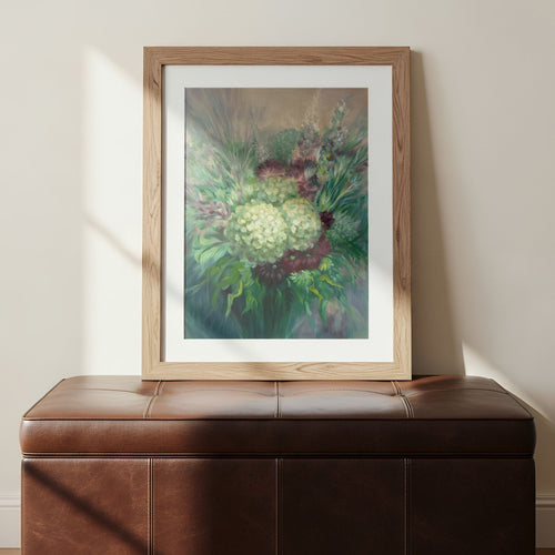Framed art print of impressionism-style floral art on a brown leather bench against a beige wall